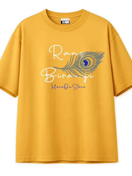 Front view of a mustard yellow oversized t-shirt with a single detailed peacock feather across the chest and "Rang Birangi" and "MoreOnStore" text in white and blue.