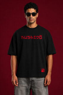 Front view of a black oversized streetwear t-shirt featuring the word "BUSHIDO" in red Japanese-inspired typography across the chest, styled with grey denim on a male model.