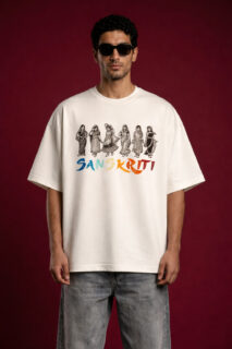 Front view of a man wearing an off-white oversized t-shirt featuring "Sanskriti" branding. The design includes a row of six traditional Indian figures in folk attire in a black linocut style, positioned above colorful brushstroke typography. The model is wearing black sunglasses and light-wash denim against a deep maroon background.