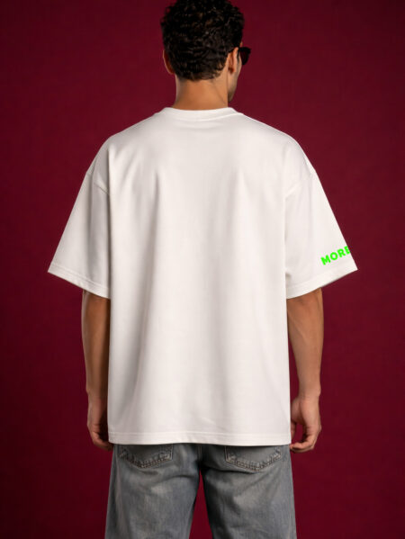 Back view of man wearing plain oversized off-white t-shirt with relaxed fit and faded grey jeans on red background