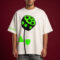 Man wearing oversized off-white t-shirt with neon green abstract flower graphic and black sunglasses against red background