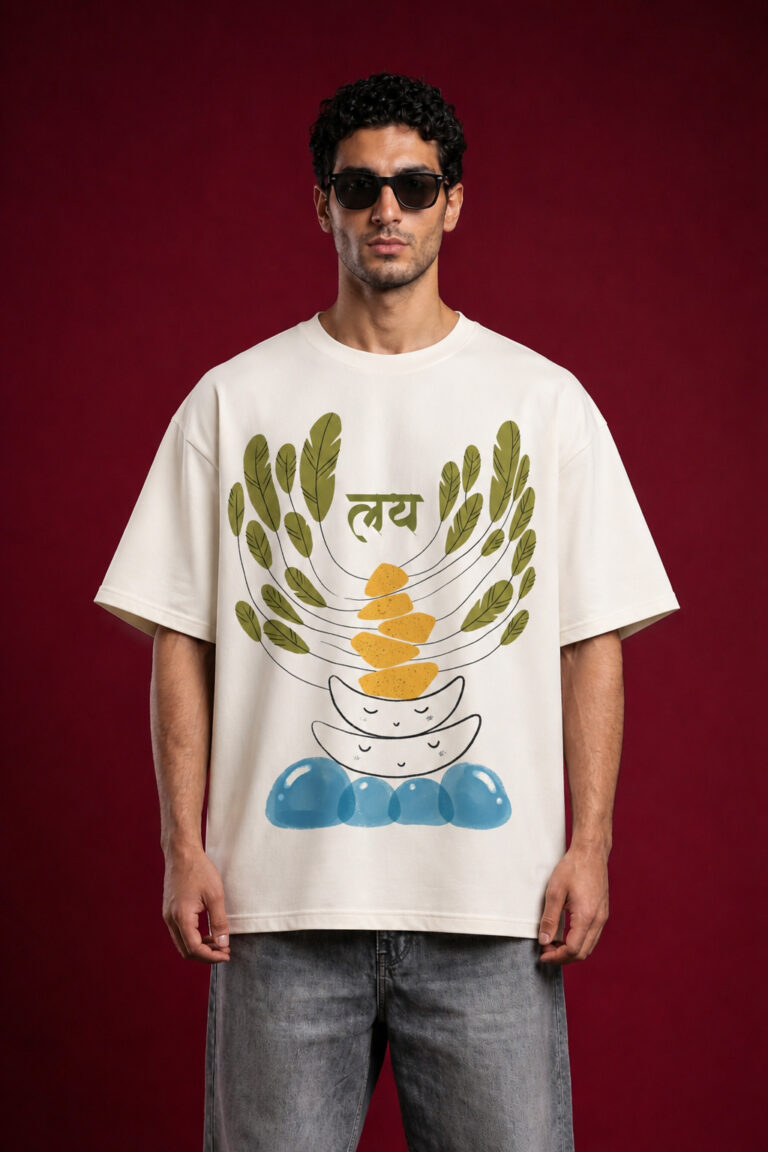 Front view of a man wearing a premium off-white oversized t-shirt featuring a "Laya" (लय) graphic with abstract balancing stones, green leaves, and blue water motifs.