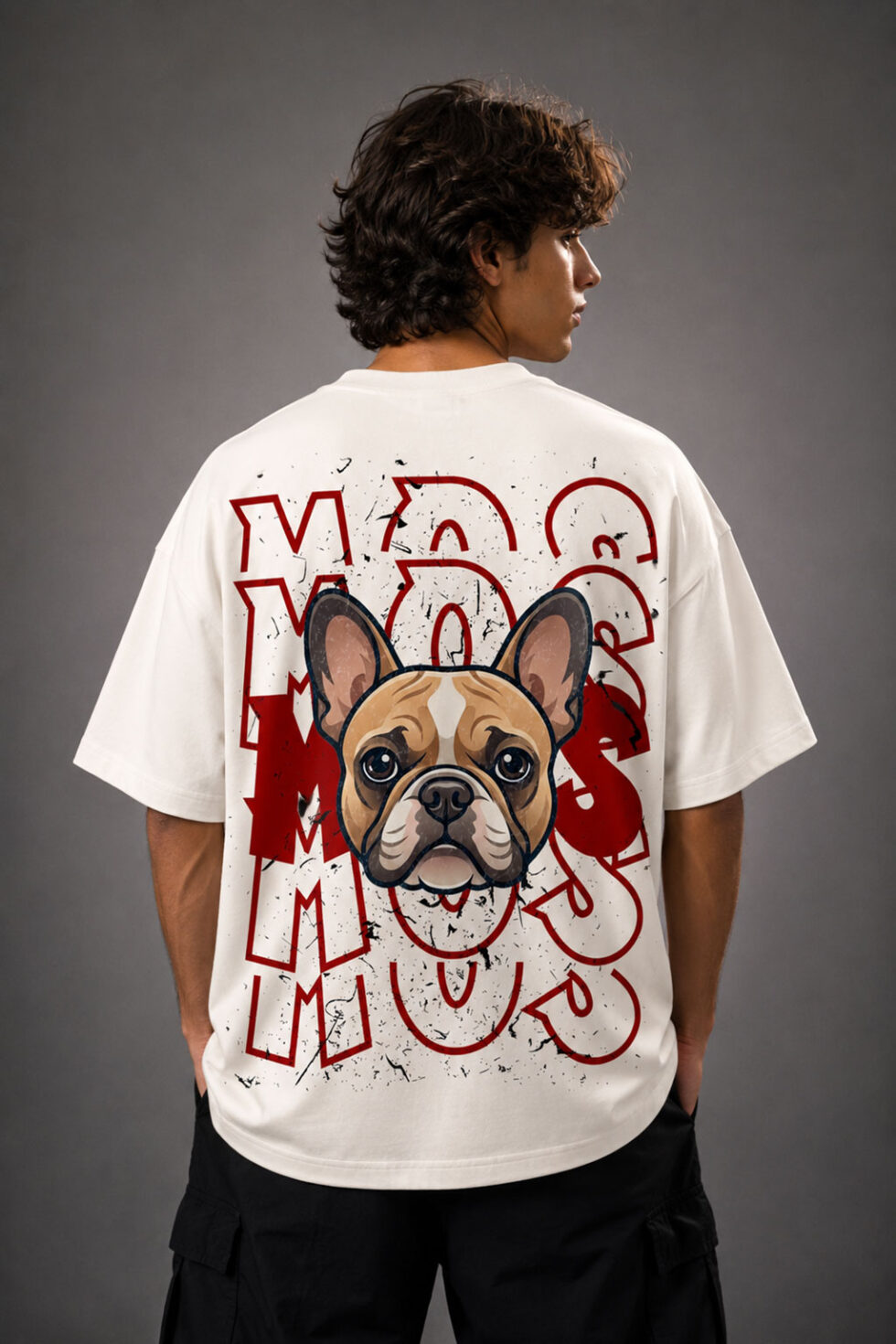 Back view of a man wearing a cream oversized streetwear t-shirt featuring a large graphic print of a French Bulldog over distressed red text