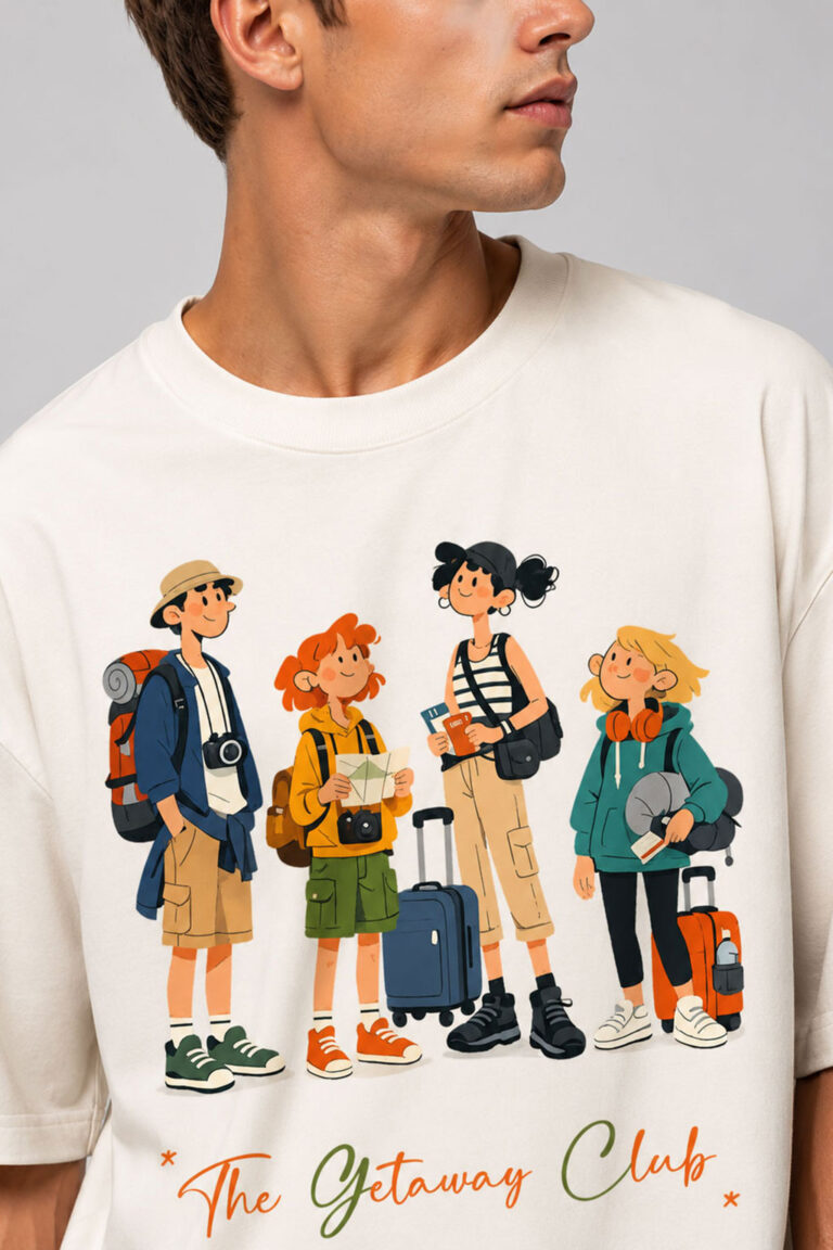 Close-up of the high-definition direct-to-garment print on a cream t-shirt, showing detailed cartoon characters holding luggage with "The Getaway Club" text below.
