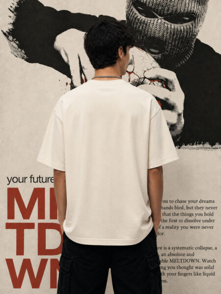 Rear view of a person wearing an off-white, minimalist oversized t-shirt against an industrial-textured backdrop, emphasizing the premium quality and structure of the heavyweight fabric